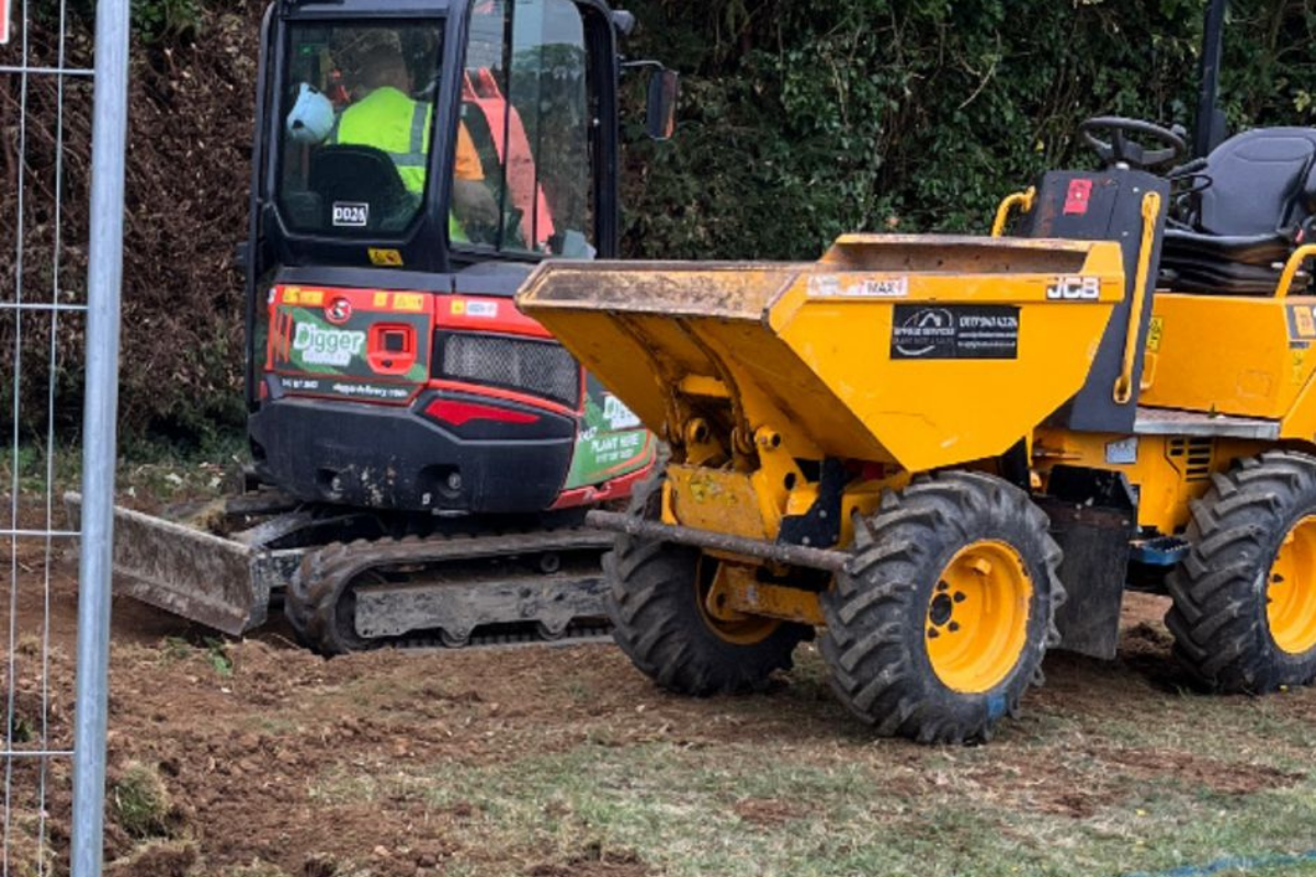 Excavator and dumper carrying out groundworks for a learning pod project in Dursley.