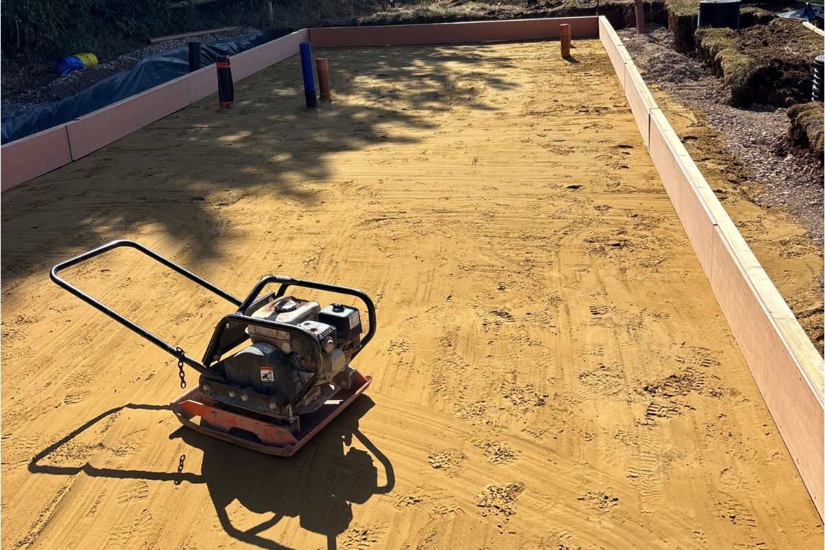 Compacted Type 1 sub-base and sand blinding prepared for a learning pod foundation.
